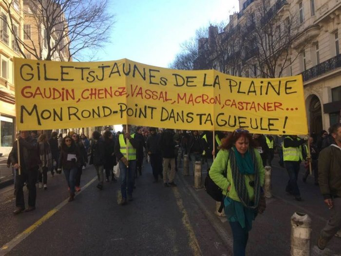 Banner reads “Yellow Vests from La Plaine” (A square in Marseille that’s being gentrified) “My roundabout in your face” (Pun on my fist in your face)
